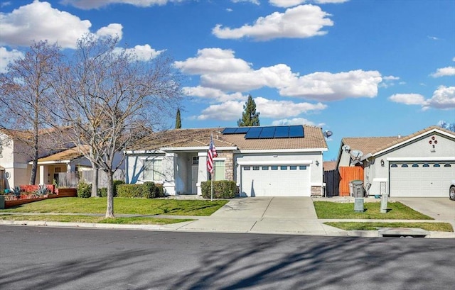 view of front facade with a garage, a front lawn, and solar panels