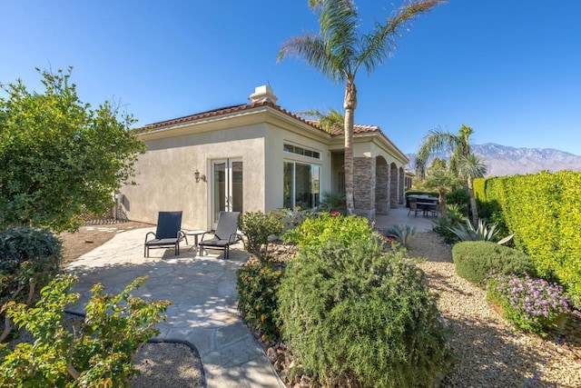 rear view of property featuring a mountain view and a patio area