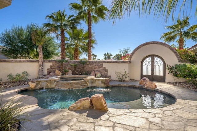 view of swimming pool featuring pool water feature and an in ground hot tub