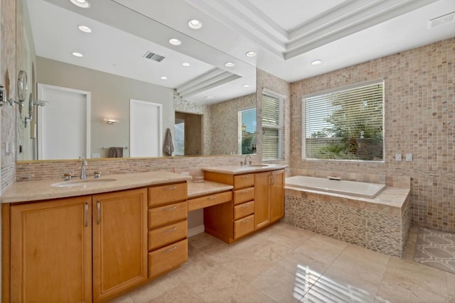 bathroom with vanity, tiled bath, and a tray ceiling