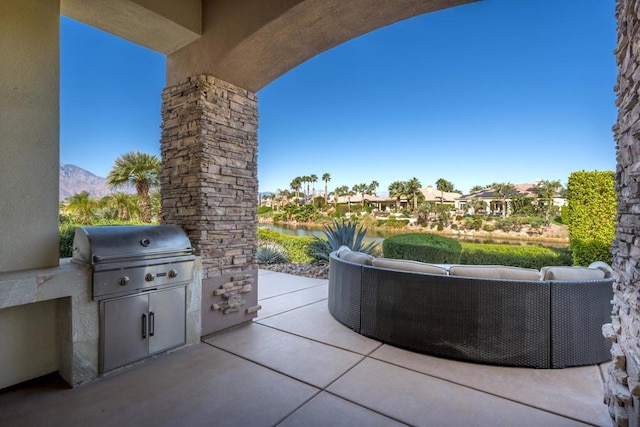 view of patio / terrace with a mountain view, an outdoor living space, an outdoor kitchen, and area for grilling