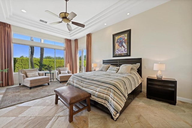 bedroom with ceiling fan and a raised ceiling