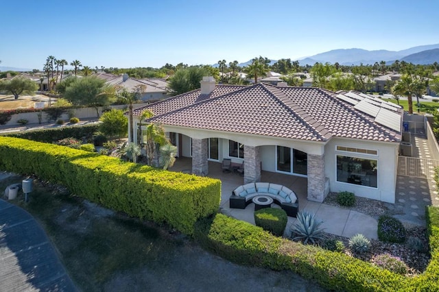 exterior space featuring a patio area, solar panels, and a mountain view