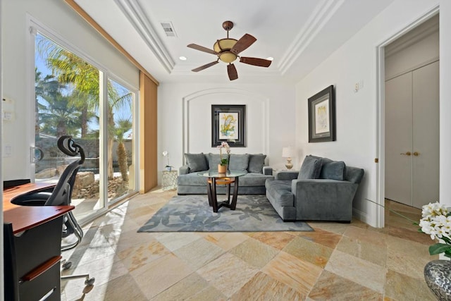 living room featuring ceiling fan and a raised ceiling