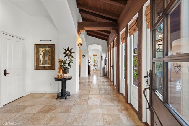 hall featuring wooden ceiling and vaulted ceiling with beams