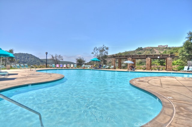 view of swimming pool with a mountain view and a patio