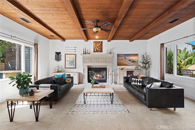 carpeted living room with beamed ceiling, plenty of natural light, and wooden ceiling