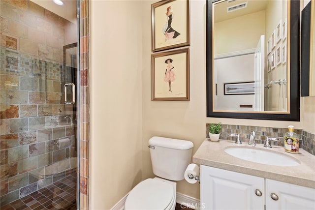 bathroom featuring a shower with door, toilet, and vanity