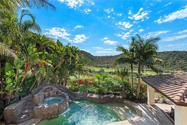 view of swimming pool with an in ground hot tub and a mountain view