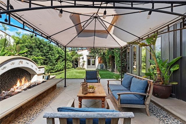 view of patio with an outdoor living space with a fireplace