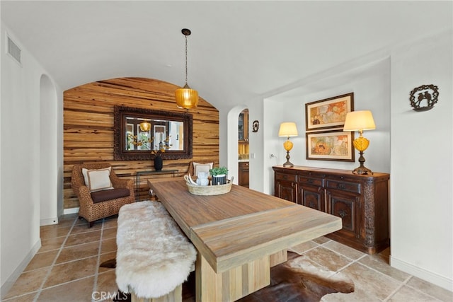 dining area with wood walls, rustic walls, and lofted ceiling