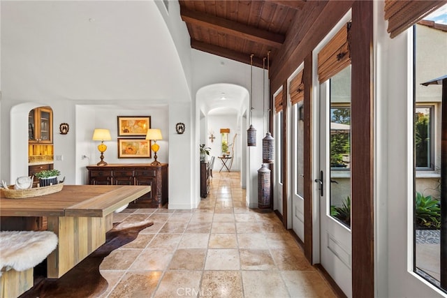 hall featuring wooden ceiling and lofted ceiling with beams