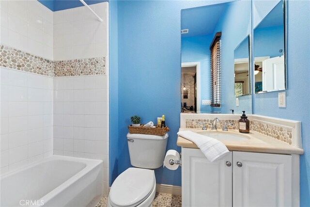 full bathroom with toilet, tiled shower / bath, decorative backsplash, and vanity