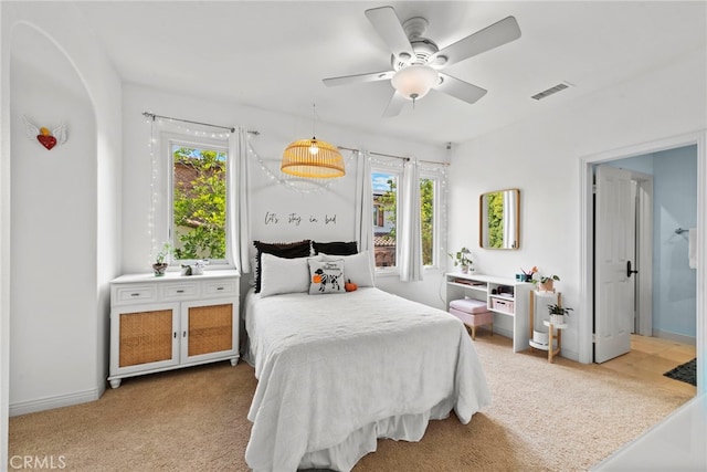 carpeted bedroom with ceiling fan and multiple windows