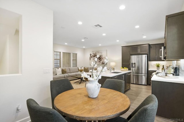 dining space with sink and light hardwood / wood-style flooring