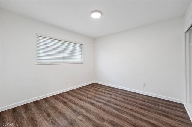 empty room with dark hardwood / wood-style flooring