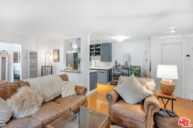 living room with indoor bar and light wood-type flooring