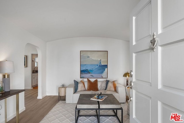 living room featuring brick ceiling, sink, vaulted ceiling, and light wood-type flooring