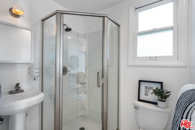 bathroom with toilet, an enclosed shower, and sink