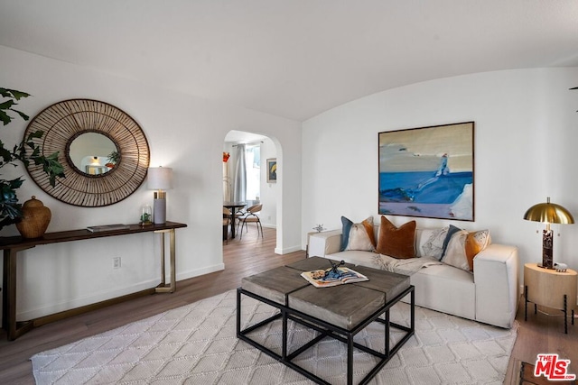 living room with brick ceiling, lofted ceiling, and light hardwood / wood-style floors