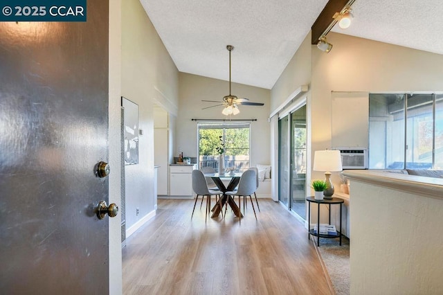 dining space with ceiling fan, light hardwood / wood-style floors, a textured ceiling, and lofted ceiling