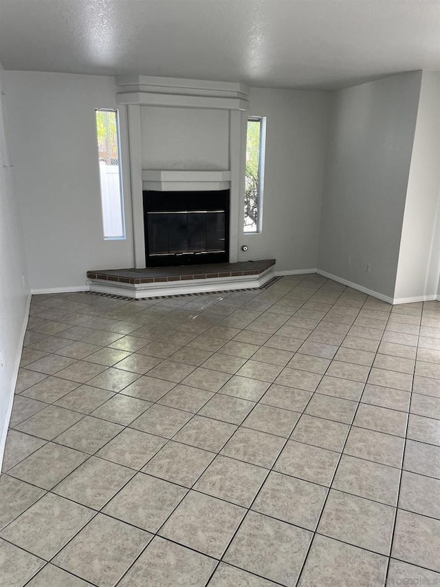 unfurnished living room featuring a textured ceiling and light tile patterned floors