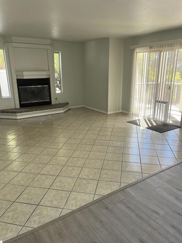 unfurnished living room with a textured ceiling and light tile patterned floors