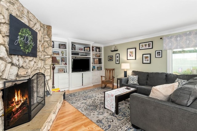 living room featuring light hardwood / wood-style flooring, a fireplace, and ornamental molding