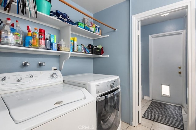 laundry room with washer and dryer and light tile patterned floors