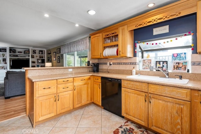 kitchen with light tile patterned flooring, black dishwasher, sink, and kitchen peninsula