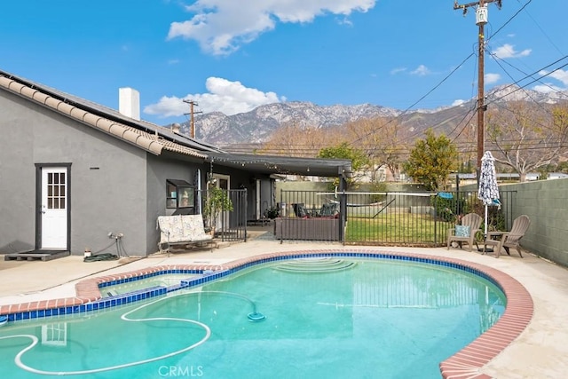 view of pool with a patio and a mountain view