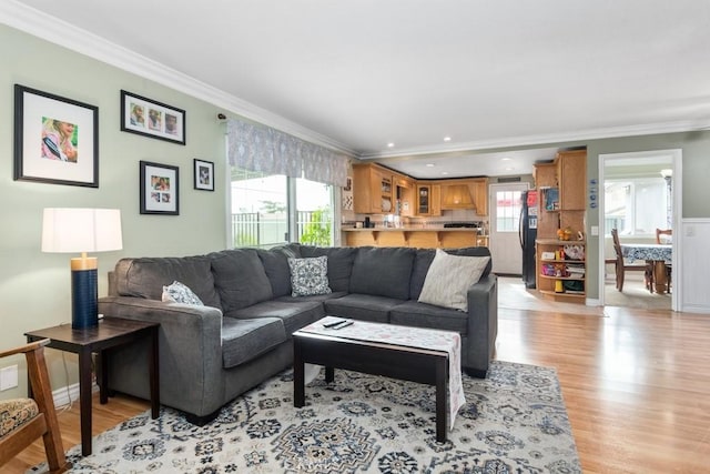 living room with crown molding and light hardwood / wood-style floors