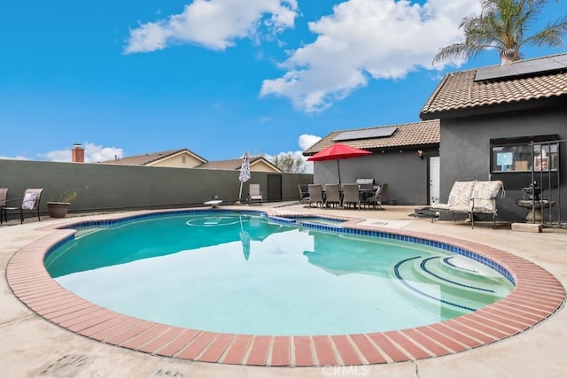 view of swimming pool featuring a patio area and a diving board