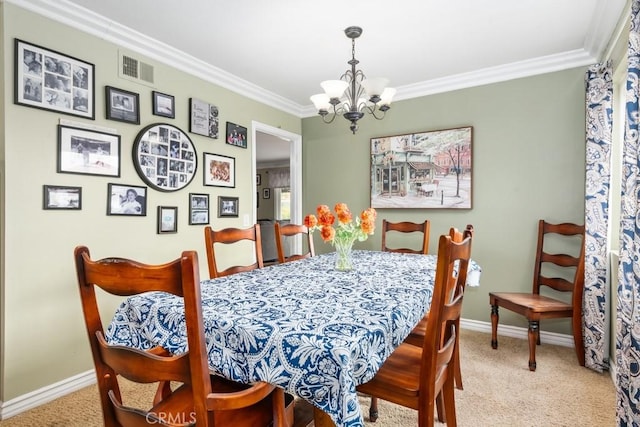 carpeted dining space with ornamental molding and a chandelier