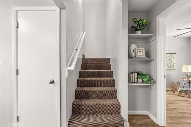 stairs featuring hardwood / wood-style floors and built in features