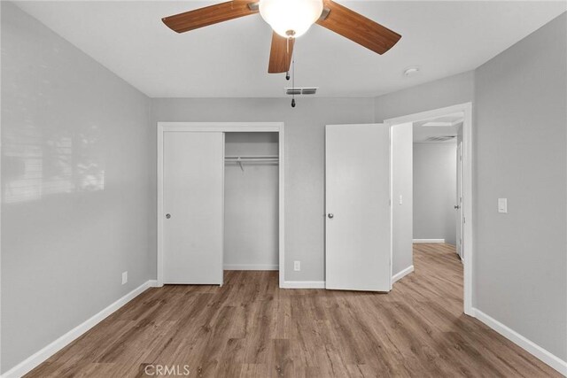 unfurnished bedroom with ceiling fan, a closet, and light hardwood / wood-style flooring