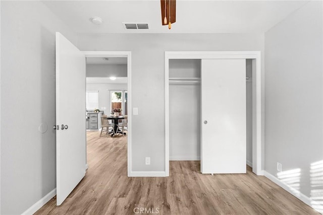 unfurnished bedroom with a closet and light wood-type flooring