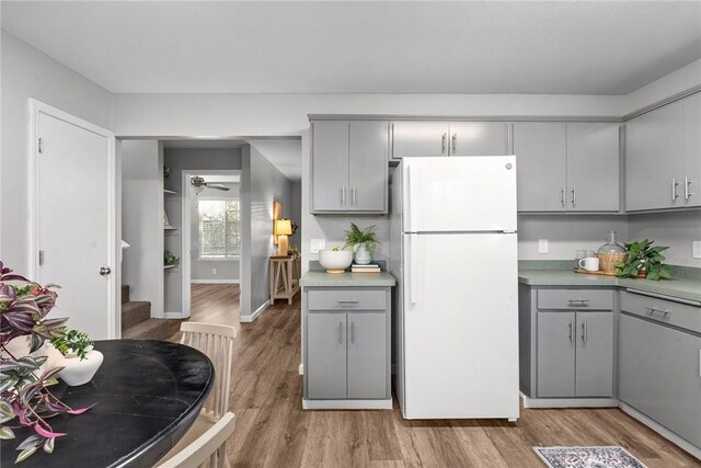 kitchen featuring gray cabinets, light hardwood / wood-style flooring, and white fridge