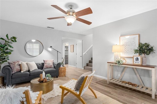 living room featuring light wood-type flooring and ceiling fan