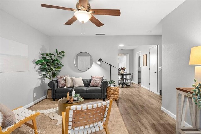 living room featuring ceiling fan and light hardwood / wood-style floors