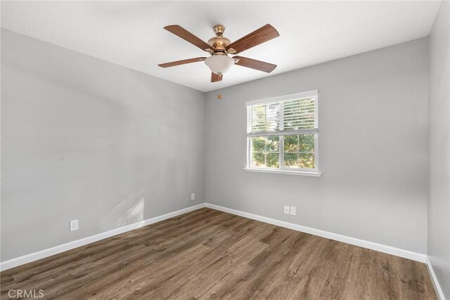 spare room with ceiling fan and dark wood-type flooring