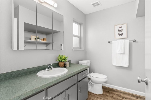 bathroom with hardwood / wood-style floors, toilet, and vanity