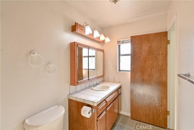 bathroom featuring toilet, vanity, and tile patterned flooring