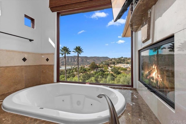 bathroom featuring a mountain view and a relaxing tiled tub