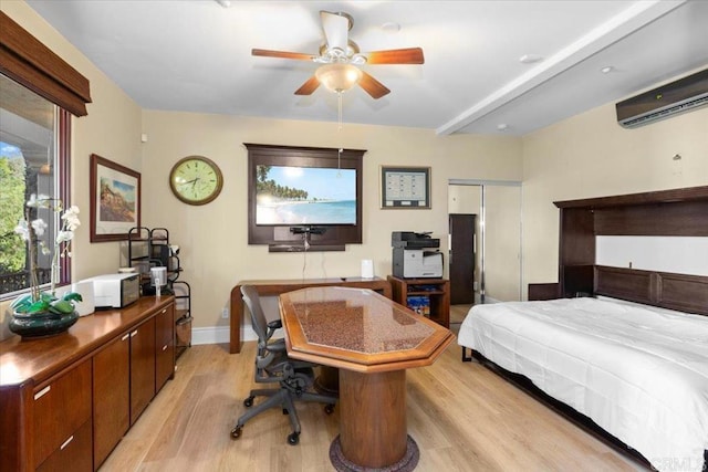 bedroom with light hardwood / wood-style floors, a wall unit AC, and ceiling fan