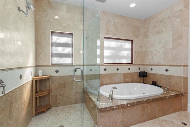 bathroom featuring tile patterned floors, tile walls, and plus walk in shower