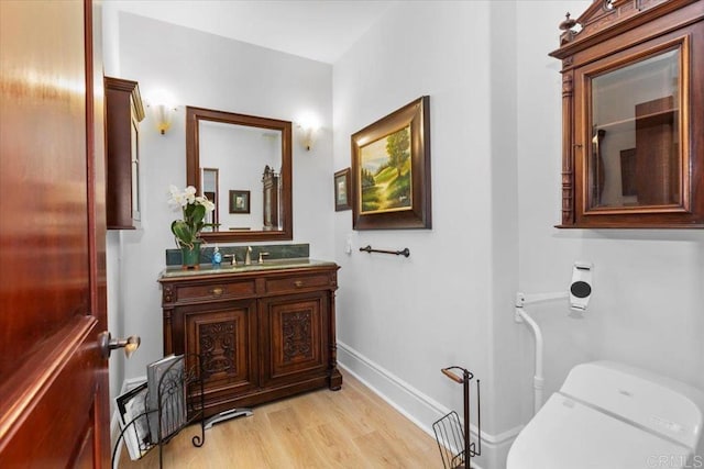 bathroom featuring hardwood / wood-style flooring, toilet, and vanity