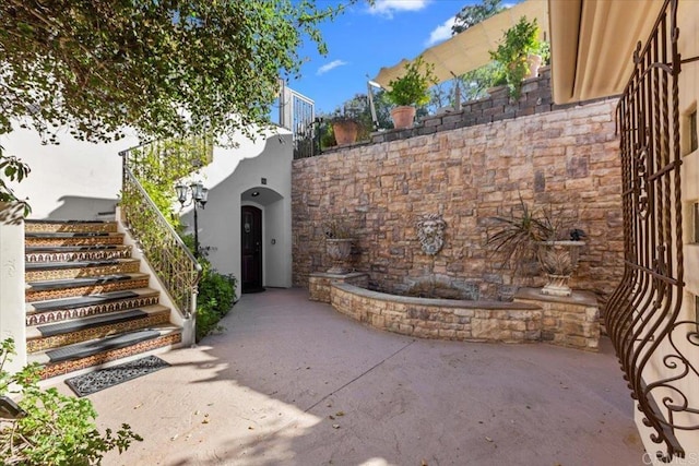 view of exterior entry with a patio area