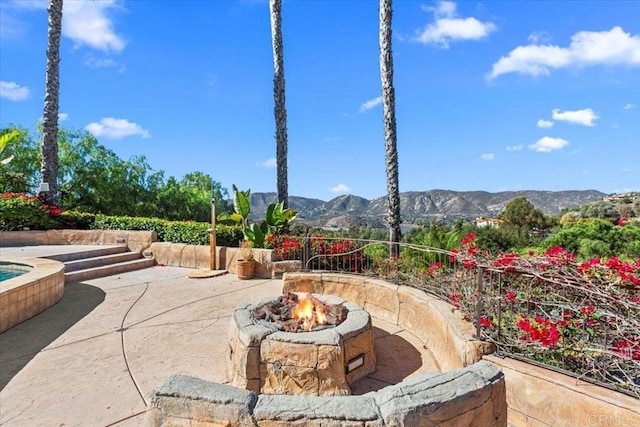 view of patio featuring a mountain view and an outdoor fire pit