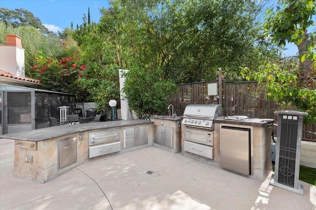 view of patio with area for grilling and sink